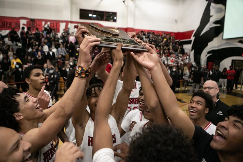 CORONA, CA - MARCH 08: Corona Centennial boy's basketball team celebrates winning the the Southern California Open Division regional basketball championship vs Sierra Canyon boy's basketball team on Tuesday, March 8, 2022 in Corona, CA.