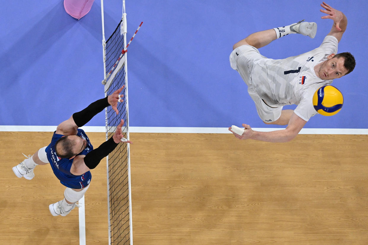 Serbia's Marko Ivovic (L) jumping to block the ball from Slovenia's #01 Toncek Stern (R) during the men's preliminary round volleyball match between. (Photo by Antonin Thuillier THUILLIER / AFP) 