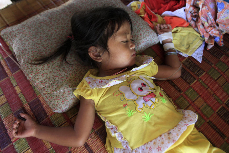 Mean Thida, 4, affected with mystery disease, sleeps at her home near a dump site at Sambour village, on the outskirts of Phnom Penh, Cambodia, Monday, July 9, 2012. A deadly form of a common childhood illness has been linked to many of the mysterious child deaths in Cambodia that caused alarm after a cause could not immediately be determined, health officials said Monday. (AP Photo/Heng Sinith)