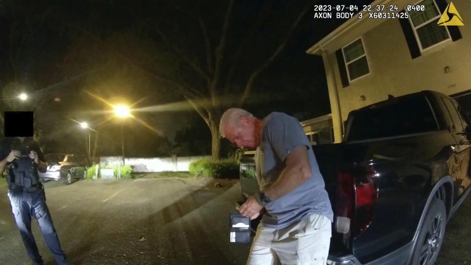In this image from video provided by the Tampa Police Department, officers talk with Joseph Ruddy, a prosecutor with the U.S. Attorney’s Office in Tampa, outside his home in Temple Terrace, Fla., on the evening of July 4, 2023. A portion of the image is obscured by the source. Ruddy, whose blood-alcohol level tested at 0.17%, twice the legal limit, was charged with driving under the influence with property damage — a first-degree misdemeanor punishable by up to a year in prison. Despite his own admissions and witness testimony, he was not charged with leaving the scene of an accident. (Officer Taylor Grant/Tampa Police Department)