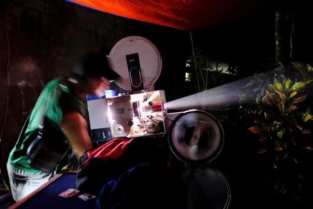 An operator adjusts a film projector during a wedding party in Bogor, Indonesia, February 18, 2017. REUTERS/Beawiharta/Files