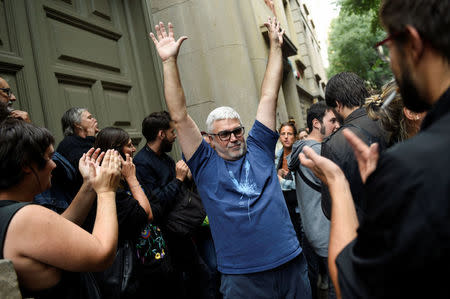 A man reacts as he is applauded by people outside a polling station after casting his vote for the banned independence referendum in Barcelona, Spain, October 1, 2017. REUTERS/Eloy Alonso
