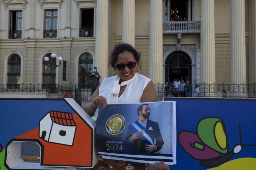 Marleny Machado sostiene un cartel del presidente de El Salvador, Nayib Bukele