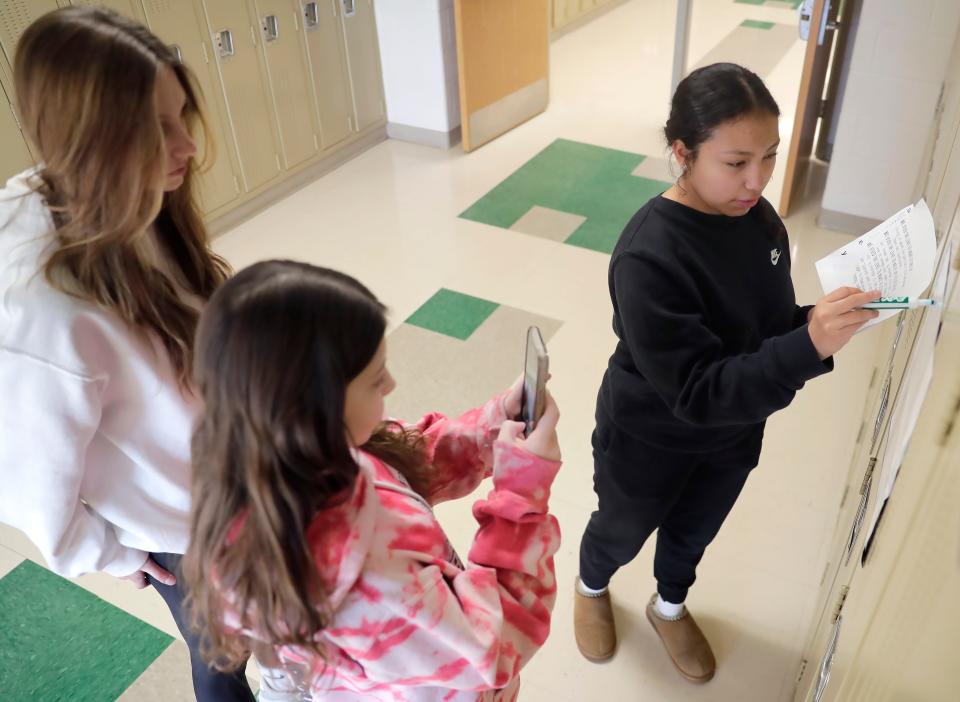 Greenville Middle School students Julia DeBruin, left, Kenia Torres, center, and Peyton Seger use a cellphone to create a video for their math class.