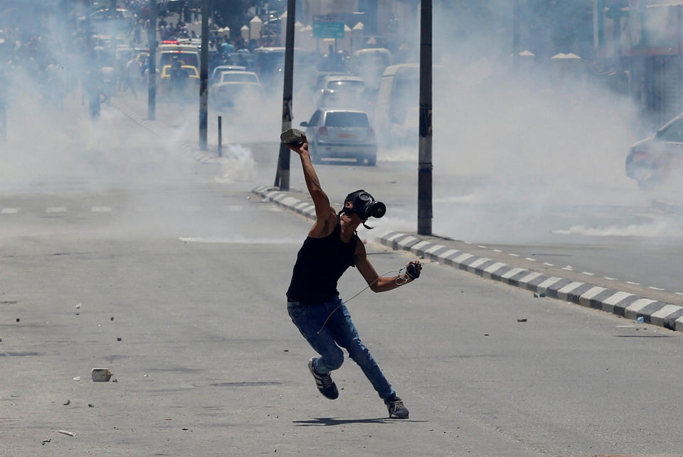 Palestinian protester hurls stones towards Israeli troops during clashes in Bethlehem