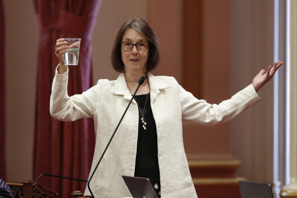 State Sen. Nancy Skinner, D-Berkeley holds up a glass of water as she describes the state budget plan in the optimistically as being half-full, as lawmakers debated the 2019-2020 spending plan in Sacramento, Calif., Thursday, June 13, 2019. Both houses of the Legislature approved the $214.8 billion state budget that spends more on health care and education, bolsters the state's top firefighting agency and boost state reserves.(AP Photo/Rich Pedroncelli)