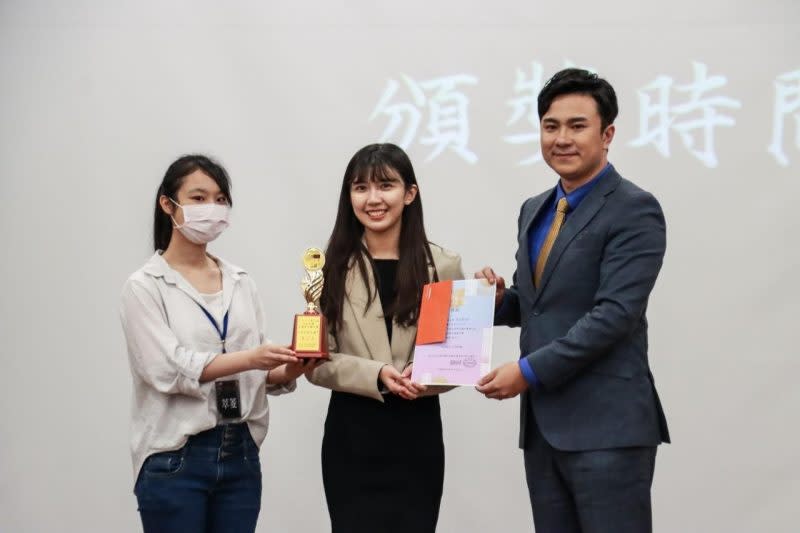 第三名由世新大學新聞系學生陳畇蓁獲得，並與TVBS記者兼任主播藍于洺合影。（世新大學提供）