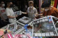 People queue up at a newspaper booth to buy last copy of Apple Daily in Hong Kong, early Thursday, June 24, 2021. Hong Kong's pro-democracy Apple Daily newspaper will stop publishing Thursday, following last week's arrest of five editors and executives and the freezing of $2.3 million in assets under the city's year-old national security law. ( AP Photo/Vincent Yu)