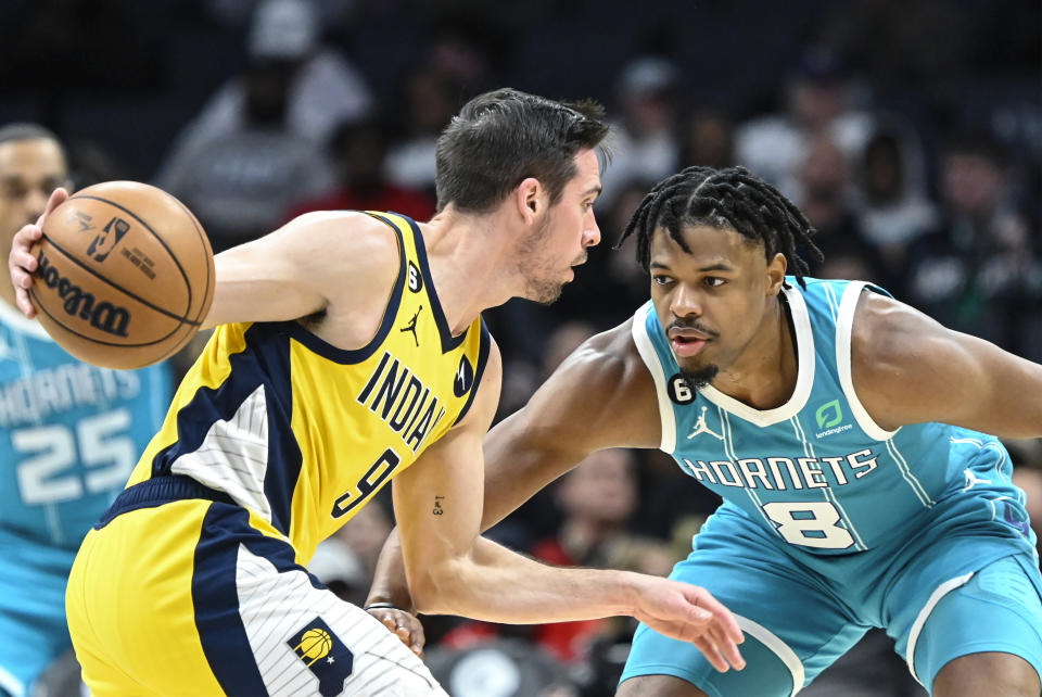 Charlotte Hornets guard Dennis Smith Jr. (8) defends against Indiana Pacers guard T.J. McConnell (9) during the first half of an NBA basketball game, Monday, March 20, 2023, in Charlotte, N.C. (AP Photo/Matt Kelley)