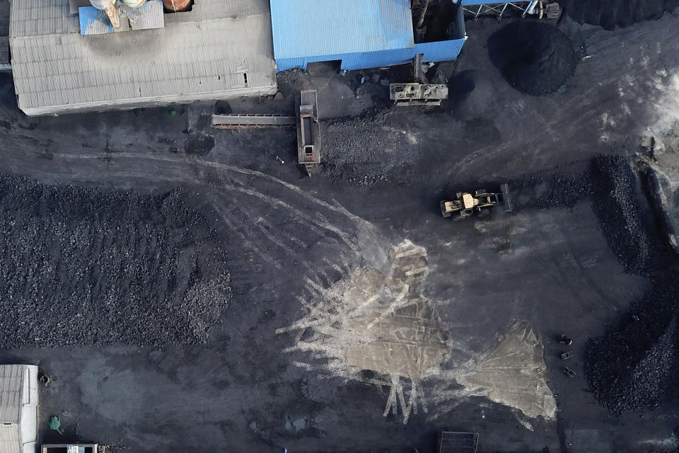 In this Nov. 28, 2019, photo, a coal storage facility is seen in Hejin in central China's Shanxi Province. As world leaders gather in Madrid to discuss how to slow the warming of the planet, a spotlight is falling on China, the top emitter of greenhouse gases. China burns about half the coal used globally each year. Yet it's also the leading market for solar panels, wind turbines and electric vehicles. (AP Photo/Sam McNeil)