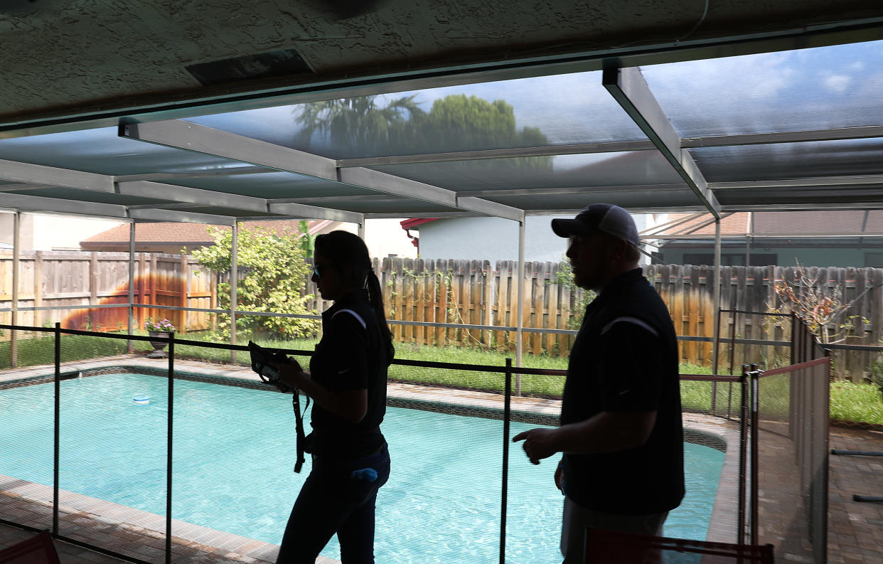 Claudia Teyssandier, Zillow Offers Renovation Estimator, and J Myers, Zillow Offers National Renovation Manager, evaluate a home for a possible purchase in Lauderhill, Florida. (Credit: Joe Raedle,Getty Images)