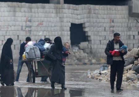 Civilians carry their belongings as they flee deeper into the remaining rebel-held areas of Aleppo, Syria December 7, 2016. REUTERS/Abdalrhman Ismail