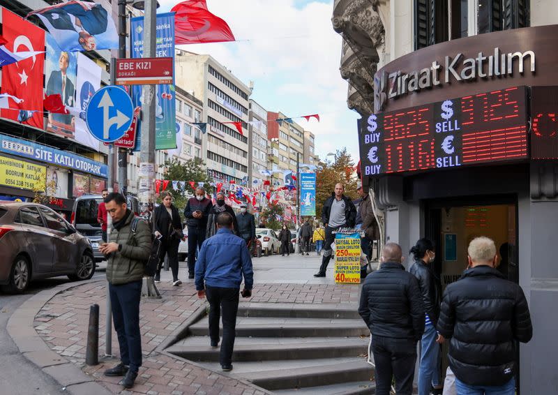 People wait in line to buy and sell money at a currency exchange office in Istanbul