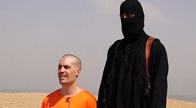 A video shows a prisoner in orange being forced to kneel and recite a message to the United States of America. Photo: Twitter.