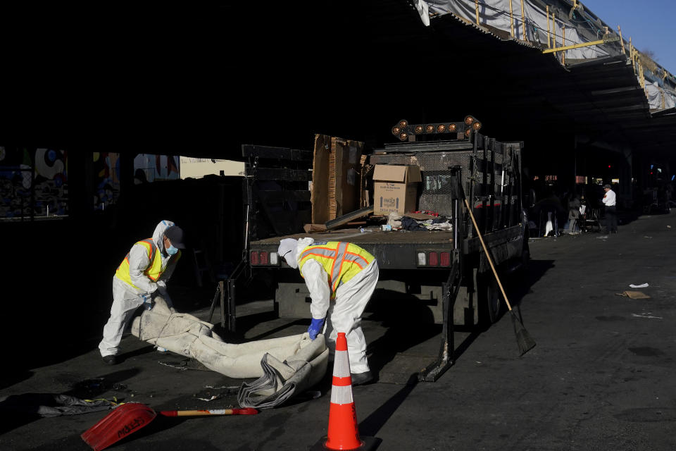 San Francisco Public Works crew load a truck while cleaning items from a homeless encampment in San Francisco, Tuesday, Aug. 29, 2023. Cities across the U.S. are struggling with and cracking down on tent encampments as the number of homeless people grows, largely due to a lack of affordable housing. Homeless people and their advocates say sweeps are cruel and costly, and there aren't enough homes or beds for everyone. (AP Photo/Jeff Chiu)