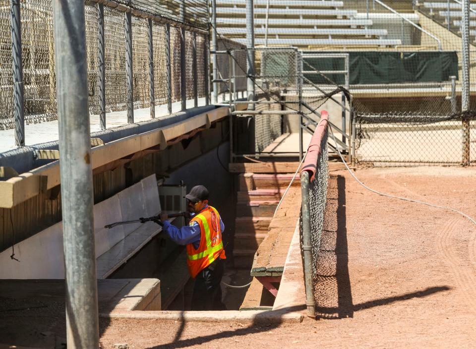 A city worker pressure washes the dugouts at Palm Springs Stadium in Palm Springs, Calif., Wednesday, May 25, 2022.