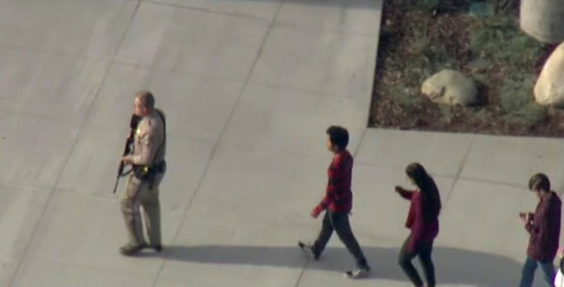 A law enforcement official leads students at the scene of a shooting at Saugus high school in Santa Clarita