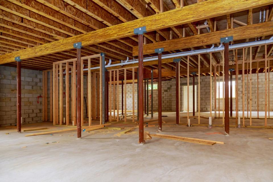 A wide view of a basement in the process of being framed. 