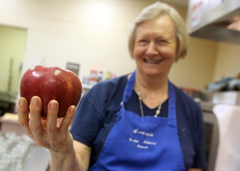 Martha Hester holds a Rome apple at Aldersgate United Methodist Church, which hosts the annual Apple Butter Festival on Saturday. [Brittany Randolph/The Star]