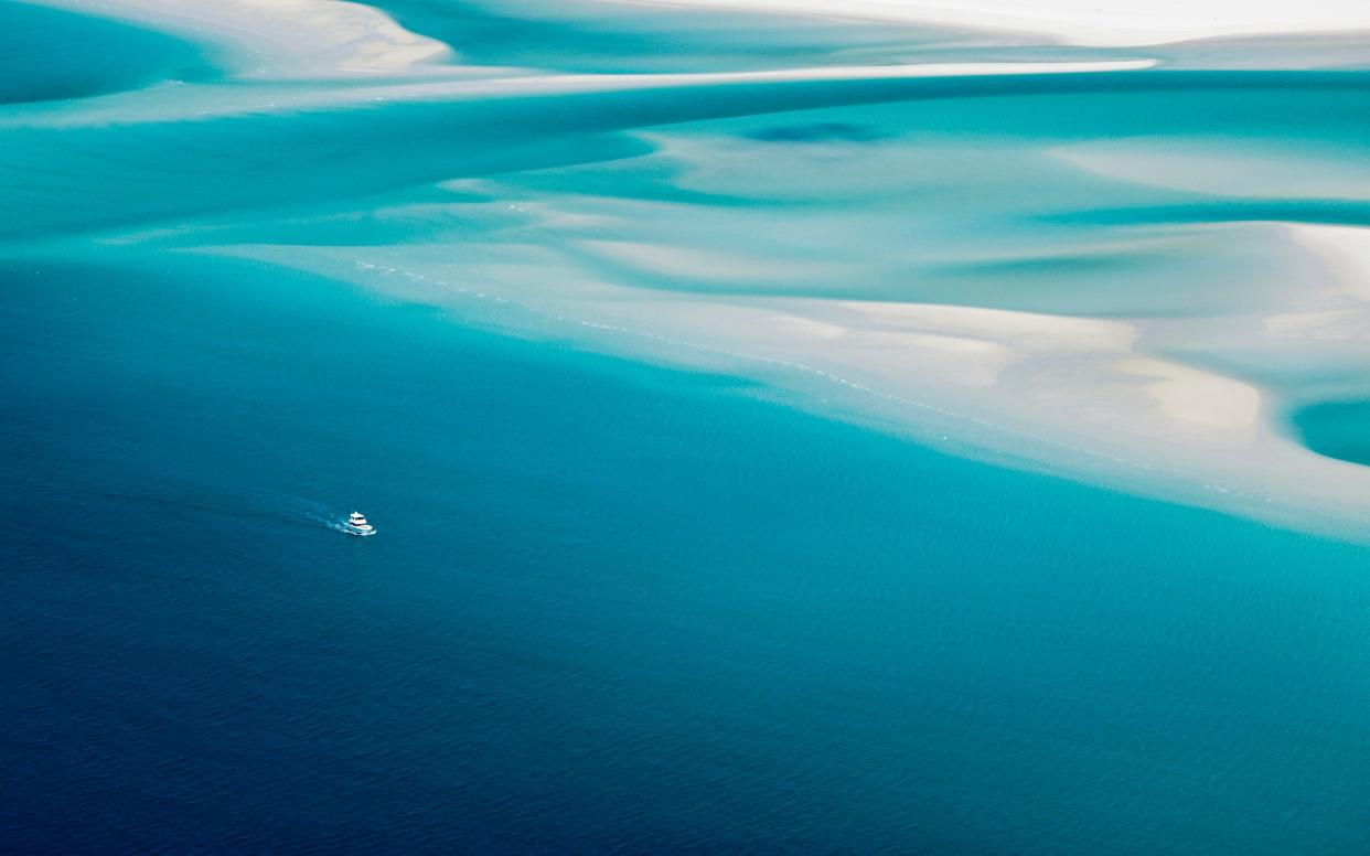 A lone boat approaches the periphery of Queensland's famed Whitehaven Beach - Andrew Watson
