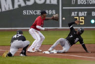 Chicago White Sox's Tim Anderson (7) slides into third base ahead of the throw to Boston Red Sox third baseman Rafael Devers on a single by Jose Abreu, as third base coach Joe McEwing (47) watches during the first inning of a baseball game at Fenway Park, Friday, May 6, 2022, in Boston. (AP Photo/Mary Schwalm)