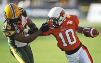 Edmonton Eskimos' Weldon Brown, left, collects a penalty for grabbing the face mask of B.C. Lions' Kierrie Johnson during first quarter CFL pre-season football action in Edmonton, Alta., Thursday, June 21, 2012. THE CANADIAN PRESS/John Ulan