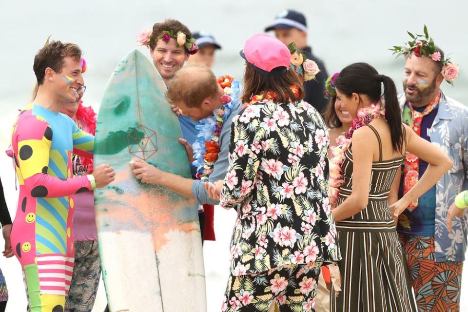 Prince Harry waxing a surfboard