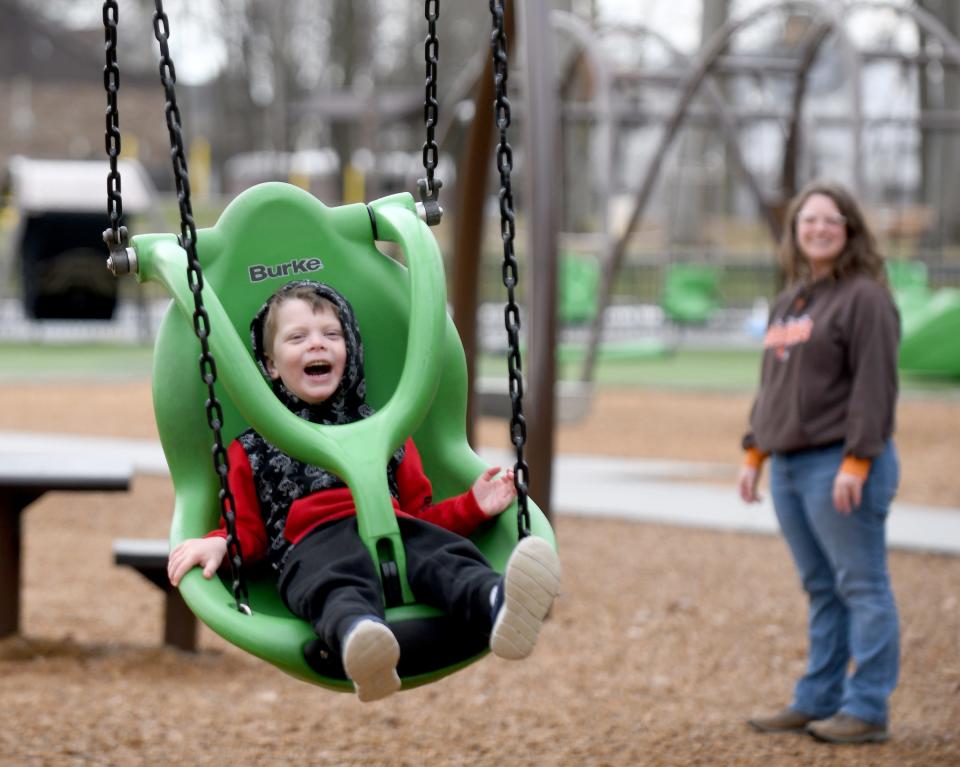 Ronan Devitto-Skiles, 4, of Canton enjoys a trip to the Dogwood Possibility Playground in North Canton with mother, Kayla Devitto, right, on an unseasonably warm day.