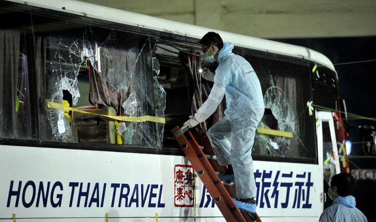 Members of a Hong Kong police forensic team examine the tourist bus used in the Manila bus hijacking in which eight Hong Kong tourists died on August 23, 2010