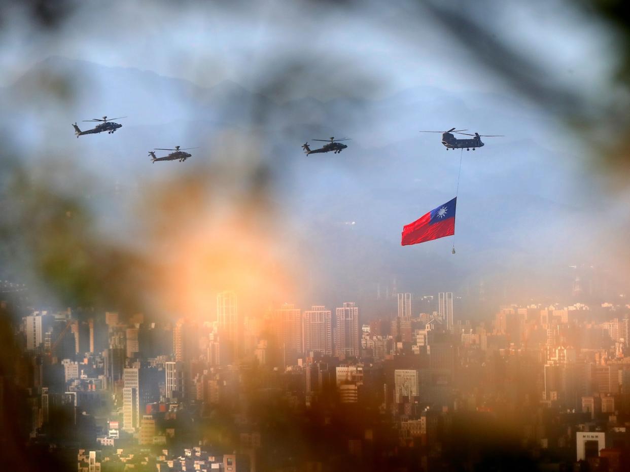 Military helicopters carrying large Taiwan flags conduct a flyby rehearsal
