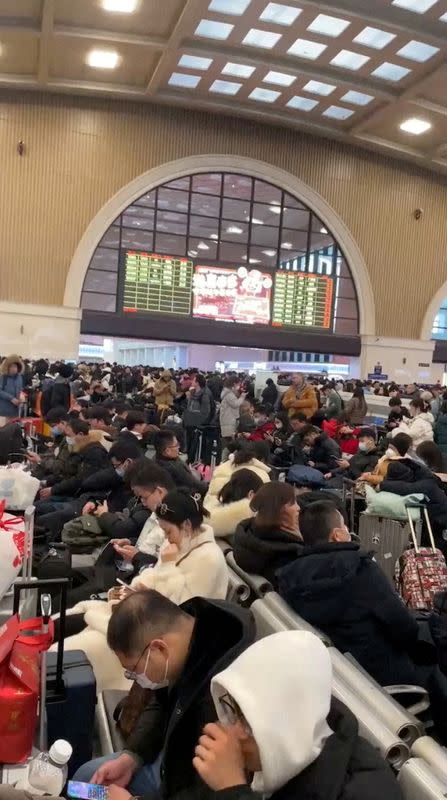 Travellers wait at a railway station in Jianghan district