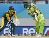 Pakistan's Shahid Afridi hits a six watched by South Africa's Quinton De Kock (L) during Pakistan's Cricket World Cup match in Auckland, March 7, 2015. REUTERS/Nigel Marple