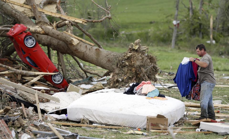 Bobby Shelton helps to salvage items at the destroyed home of his friend, Adam Danner, on Tuesday, April 29, 2014, in Fayetteville, Tenn. Around 50 tornadoes ravaged the South Monday, according to the National Oceanic and Atmospheric Administration's Storm Prediction Center. (AP Photo/Mark Humphrey)