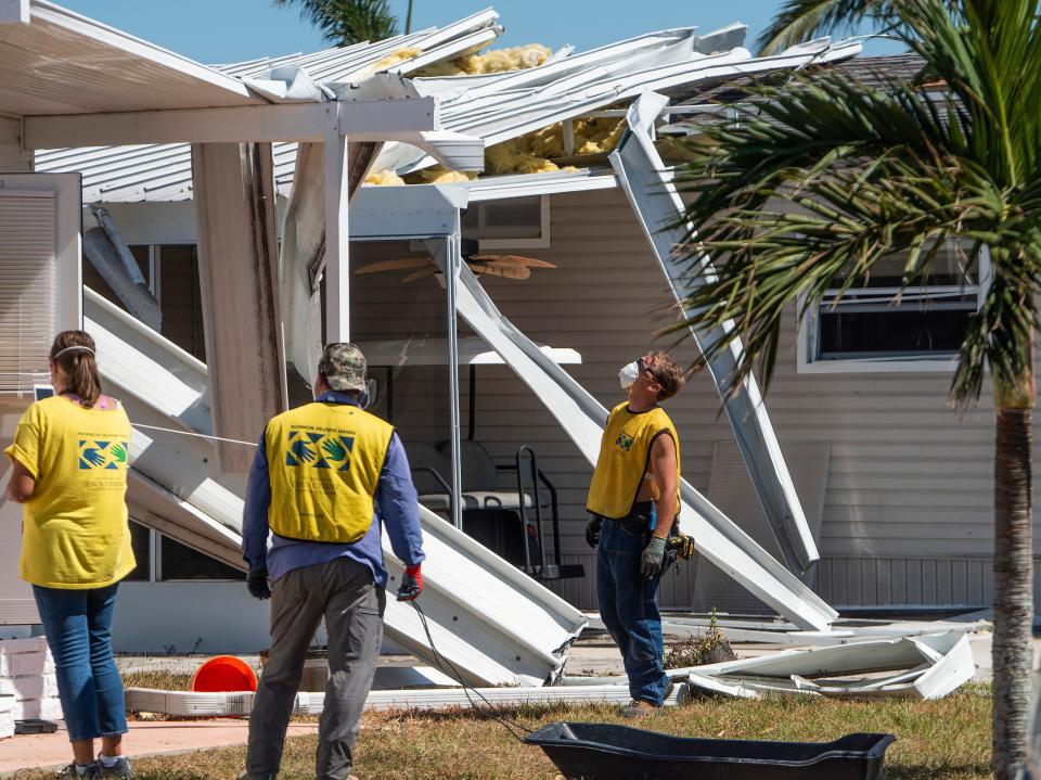 Michael Remien, right, a volunteer worker from the Crisis Cleanup program from the Church of Jesus Christ of Latter-day Saints, checks on damaged homes in the Spring Creek Village neighborhood in Bonita Springs, Fla., on Saturday October 8, 2022. Hurricane Ian hit the southwest Florida coast on Wednesday September 28th.