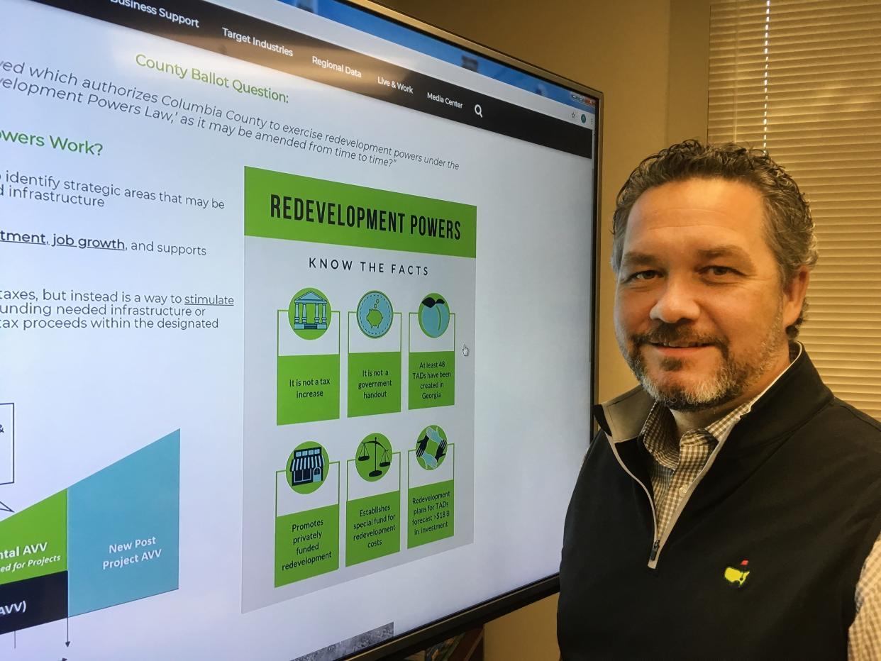 Robbie Bennett, executive director of the Development Authority of Columbia County, stands next to an information display on the organization's website about redevelopment powers the county was seeking, in this photo from 2018.