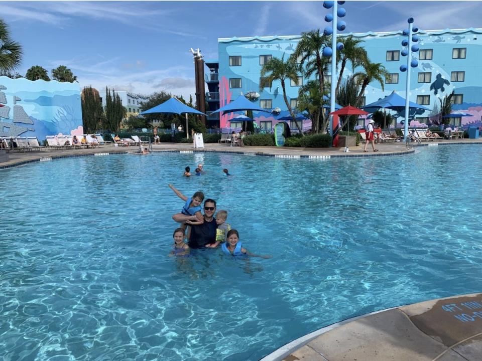 The author and his four children swimming in a relatively empty swimming pool at Disney's Art of Animation resort