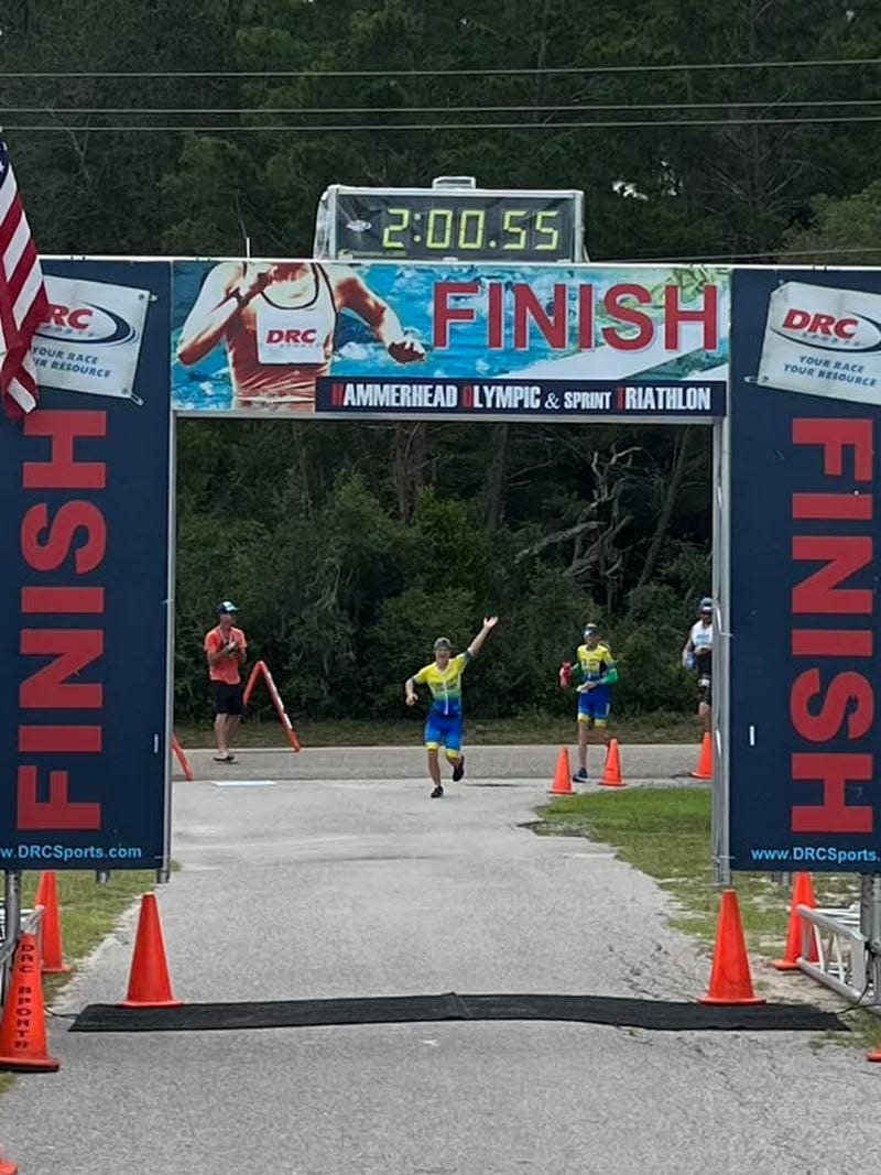 Caleb Prewitt, 16, approaches the finish line of the Hammerhead Olympic & Sprint Triathlon at Camp Blanding in Clay County on Aug. 20. He is thought to be the youngest person who has down Syndrome to complete an Olympic distance triathlon.