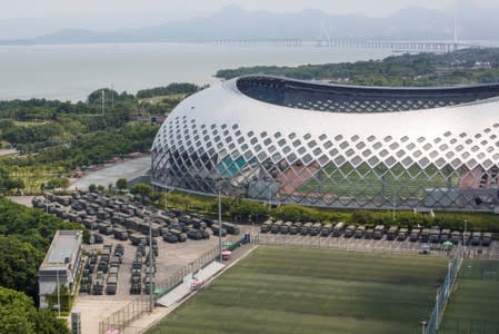 Military vehicles are parked on the grounds of the Shenzhen Bay Sports Center