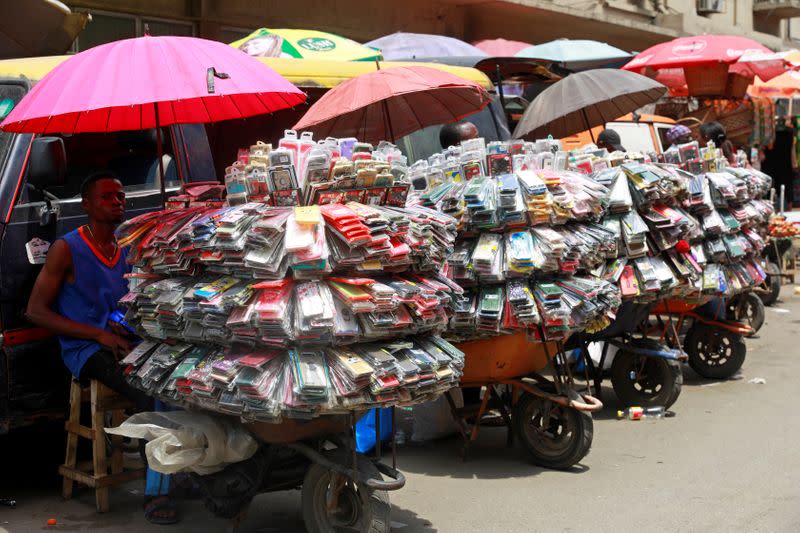 A phone accessory vendor sits beside his goods arranged in a wheelbarrow at Balogun market in Nigeria's commercial capital, Lagos