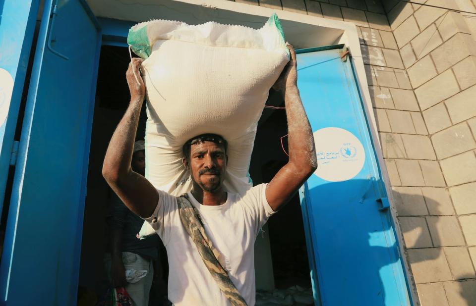 A worker carries a sack of wheat flour at a United Nations aid distribution center in Hodeidah, Yemen November 13, 2018.  Picture taken November 13, 2018. REUTERS/Abduljabbar Zeyad