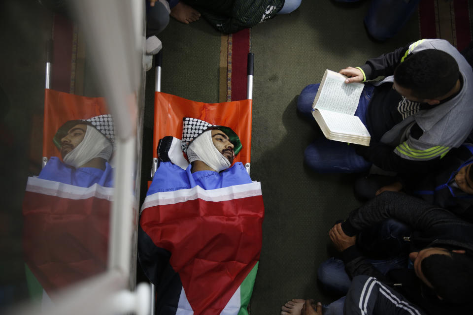 Palestinians pray by the body of Mohammed Habali 22, during his funeral in the Tulkarem refugee camp near the West Bank city of Tulkarem Tuesday, Dec. 4, 2018. (AP Photo/Majdi Mohammed)