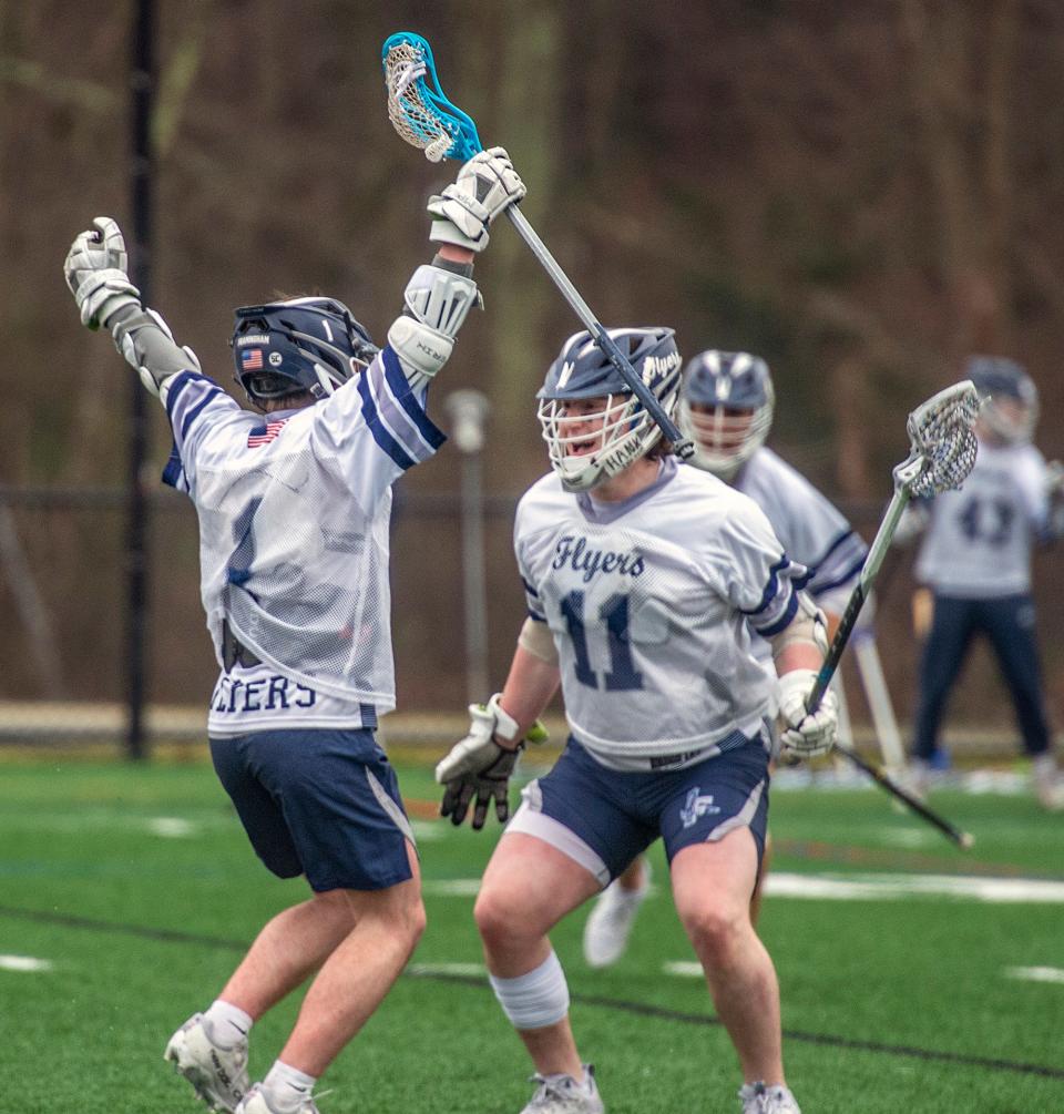 Framingham High School freshman Matt Treacy, left, after scoring the third of his five goals, is congratulated by senior Henry Goldberg, against Natick, at Fuller Field, April 11, 2024. The Flyers went on to win in overtime, 8-7, on Treacy's fifth goal.