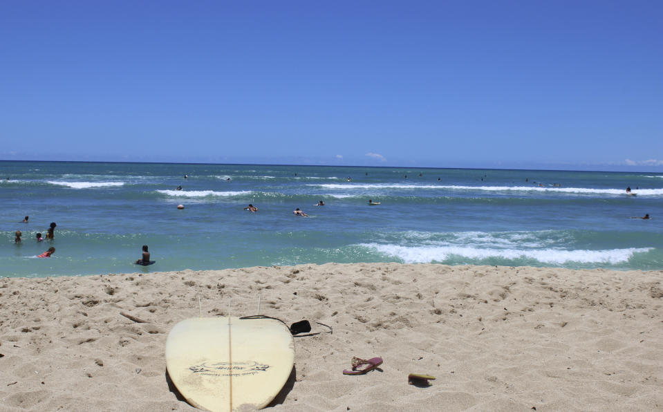 A surfboard lies on the sand on the sand at a beach known as White Plains in Ewa Beach, Hawaii, on Friday, May 12, 2023. A prominent Hawaiian waterman wants to build another Hawaii wave pool facility using the latest technology to simulate the ideal conditions top-notch surfers need to stay competitive. But some people, including fellow Hawaiians, want to stop the project and say it's a waste of water and pointless when there are many nearby beaches for surfing. (AP Photo/Jennifer Sinco Kelleher)