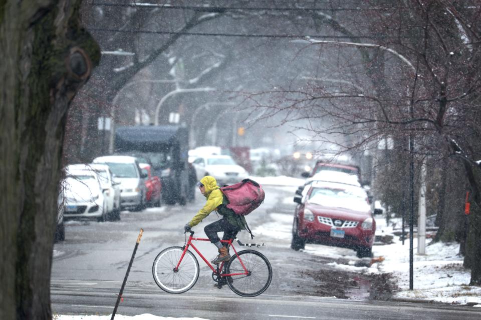 A cyclist rides his bike as snow falls in the Humboldt Park neighborhood on January 25, 2023 in Chicago, Illinois. A little more than 3 inches of wet snow fell on the city as a weather system moved across the nation dropping snow and wreaking havoc on travel from St. Louis to Boston.