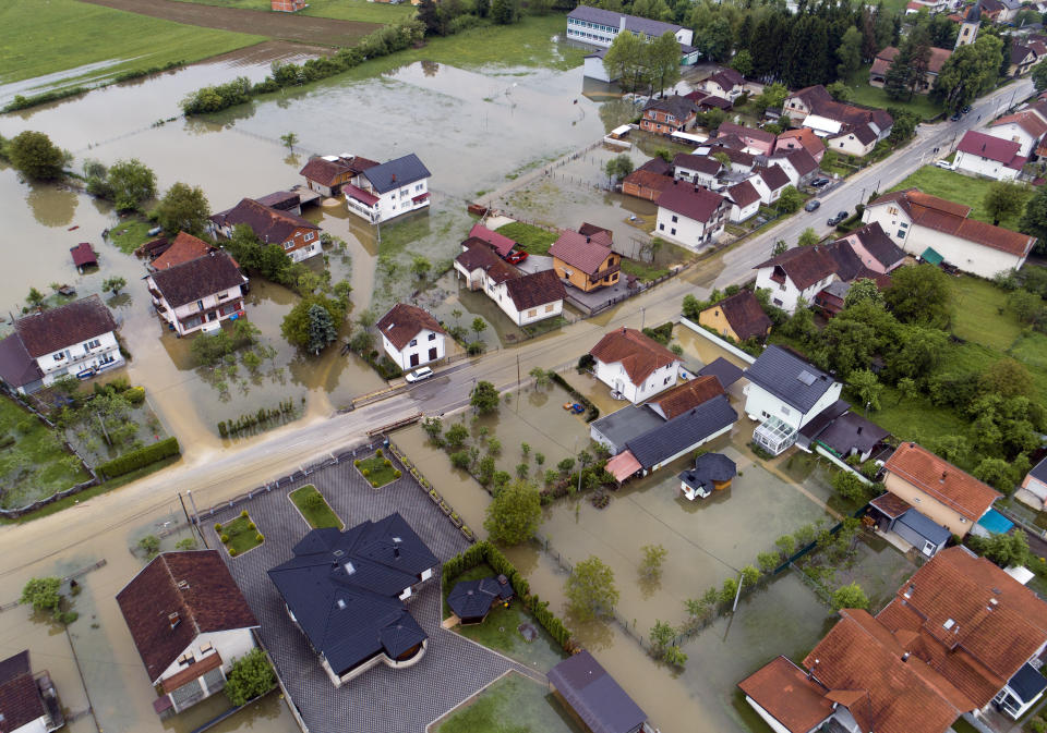 This aerial photo shows flooded neighborhood in Sanski Most, Bosnia-Herzegovina, Tuesday, May 14, 2019. Homes and roads have been flooded in parts of Bosnia after rivers broke their banks following heavy rains, triggering concerns Tuesday of a repeat of floods five years ago when dozens died. (AP Photo/Darko Bandic)