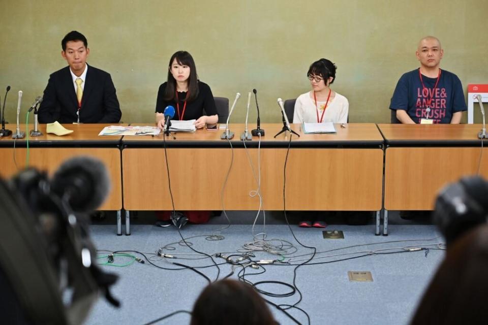 Yumi Ishikawa (second from left), leader and founder of the KuToo movement, is flanked by supporters as she delivers a speech during a press conference in Tokyo on June 3, 2019. [Photo: Getty]