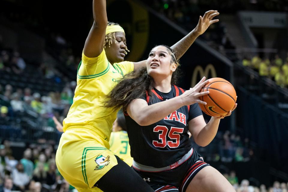 Utah forward Alissa Pili drives toward the basket under cover from Oregon center Phillipina Kyei as the Oregon Ducks host the No. 16 Utah Utes Friday, Jan. 26, 2024 at Matthew Knight Arena in Eugene, Ore.