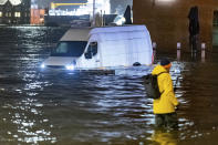 A delivery van stands in the water of the Elbe during a storm surge near the fish market in Hamburg, Germany, Thursday, Dec. 21, 2023. The Federal Maritime and Hydrographic Agency predicted a severe storm surge in Hamburg overnight due to the storm depression "Zoltan." (Bodo Marks/dpa via AP)