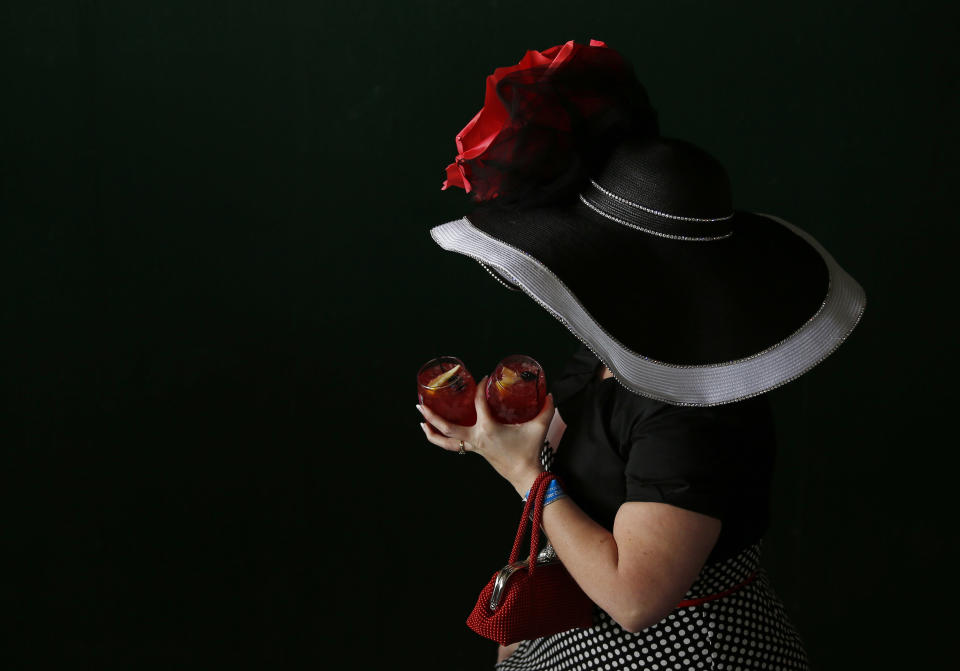 A woman makes her way to the track before the 140th running of the Kentucky Derby horse race at Churchill Downs Saturday, May 3, 2014, in Louisville, Ky. (AP Photo/Matt Slocum)