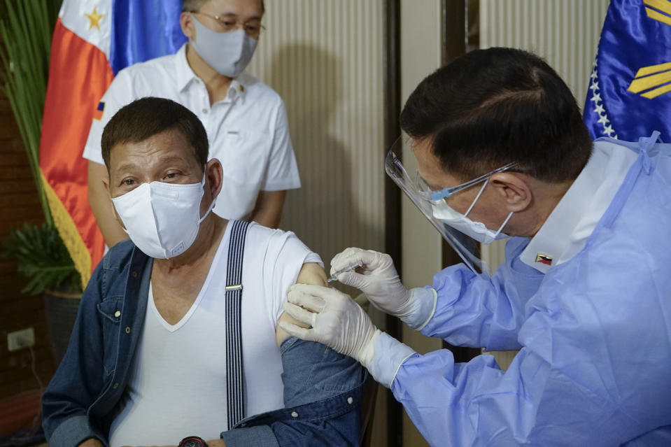 In this photo provided by the Malacanang Presidential Photographers Division, Philippine President Rodrigo Duterte, left, is inoculated with China's Sinopharm COVID-19 vaccine by Health Secretary Fracisco Duque III at the Malacanang presidential palace in Manila, Philippines on Monday May 3, 2021. (King Rodriguez/Malacanang Presidential Photographers Division via AP)